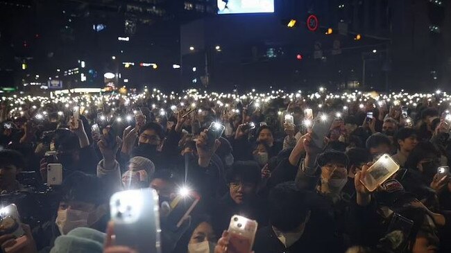 People light up their phones before midnight as they celebrate New Year's Eve in Seoul. Picture: Reuters