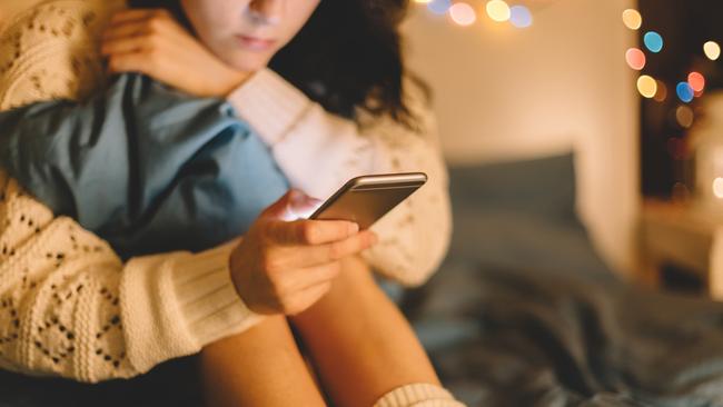 Girl in bed using phone