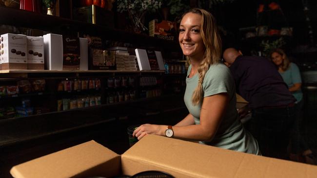 Heather Haines from Parap Fine Foods moves perishable items from the business’ in-store fridge to back-up fridge to save stock. Picture: Che Chorley