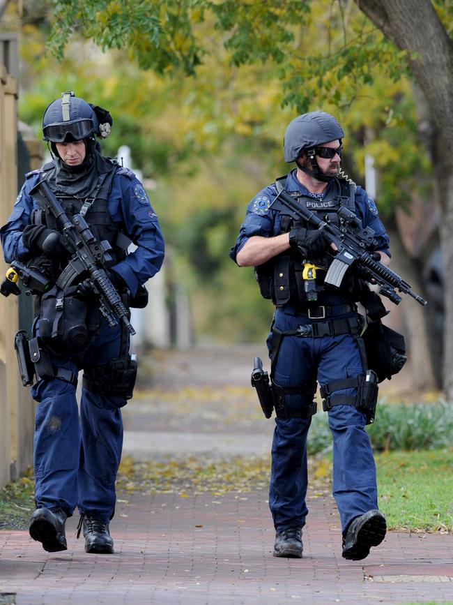 STAR Group officers with assault rifles search Prospect for two armed men.