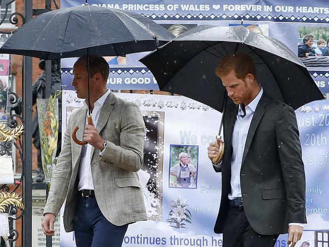 Prince William and Prince Harry walk away after placing flowers amongst the tributes to their late mother Princess Diana placed on the gates of Kensington Palace, London, Wednesday, Aug. 30, 2017. Picture: Kirsty Wigglesworth/AP