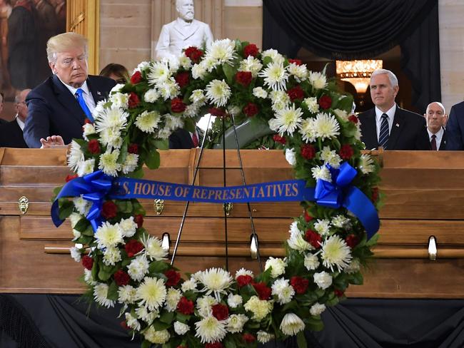 US President Donald Trump (L) places his hand on the casket of evangelist Billy Graham in the US Capitol Rotunda. Picture: AFP
