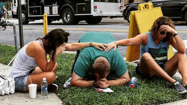 People mourn for victims of the mass shooting near the Pulse gay nightclub in Orlando. Picture: the_pixel_trappa