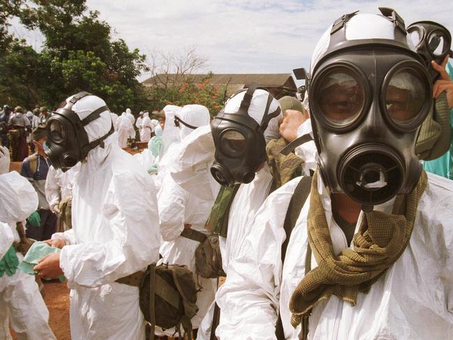 Soldiers wearing protective clothing to kill pigs in Sungai Nipah in a bid to contain an outbreak of Japanese encephalitis in Malaysia 24 Mar 1999.