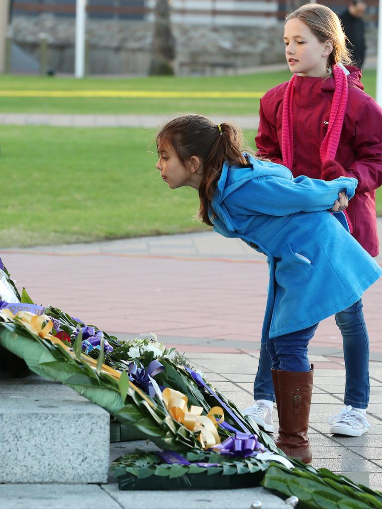 Isabella, 8, and Georgia, 10, pay their respects at the Semaphore memorial . Picture: Dylan Coker