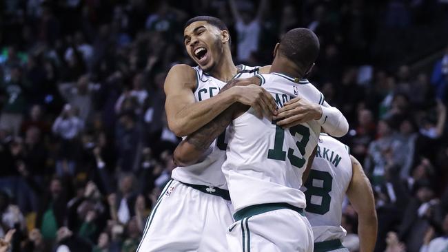 Boston Celtics forward Marcus Morris (13) leaps into the arms of teammate Jayson Tatum as they celebrate Morris' game-winning 3-point shot.