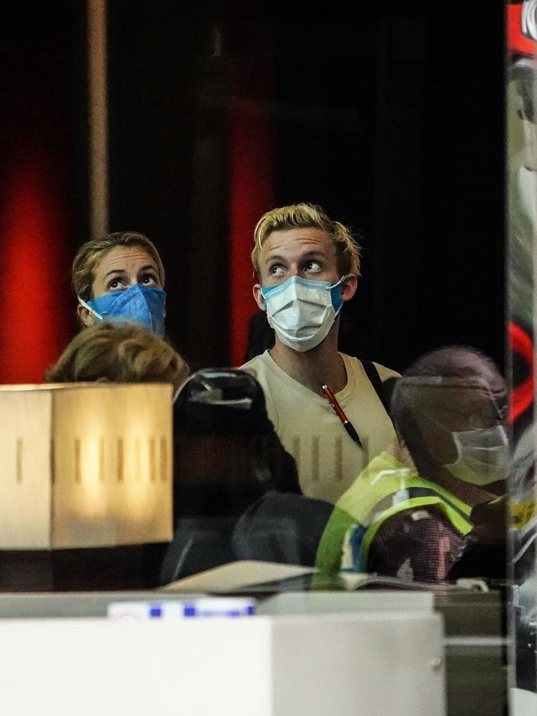 Recently arrived overseas travellers get off their bus and wait to check in at the Crown Promenade Hotel in Melbourne. Picture: AAP