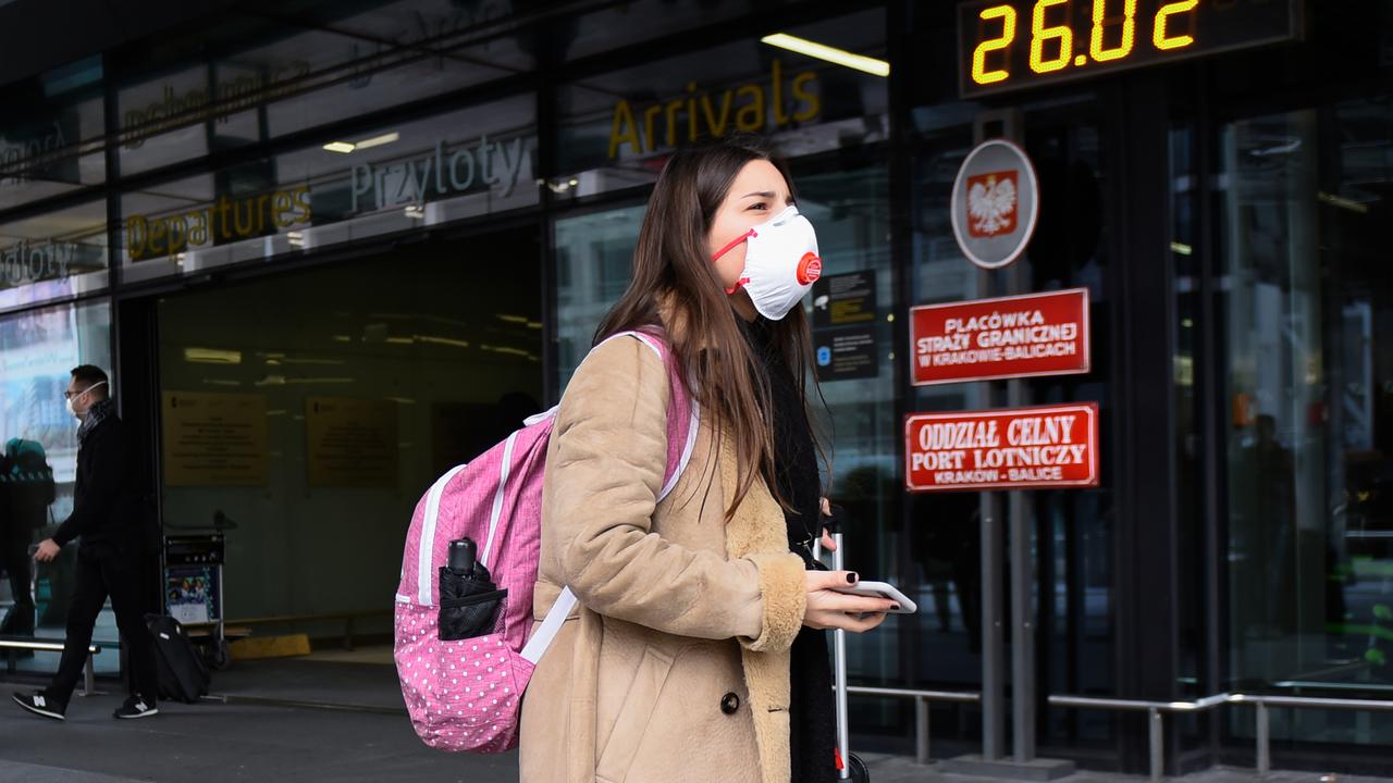 There are fears flight cuts could extend to Europe as Italy deals with a worrying outbreak. Pictured is a passenger arriving at Cracow International Airport in Poland on Wednesday. Picture: Omar Marques/Getty Images