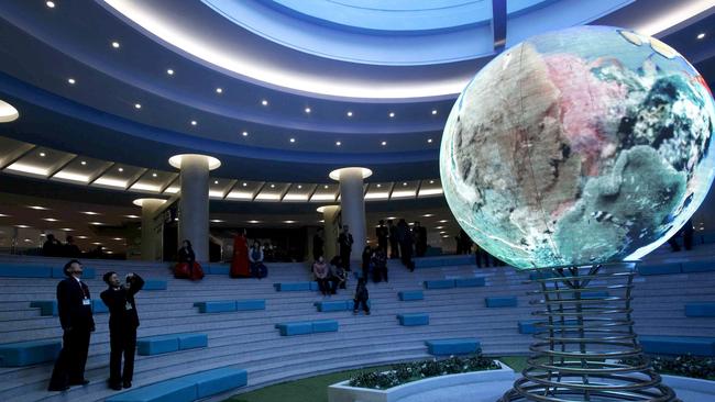 A visitor takes photos of an illuminated model of a globe at the Sci-Tech Complex in Pyongyang, North Korea.  Picture:  AP