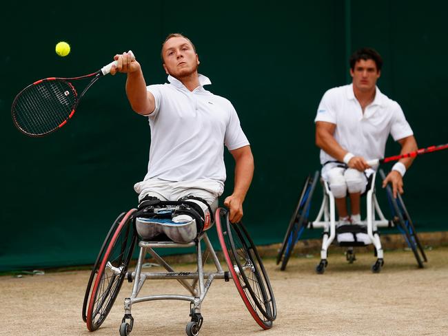 Nicolas Peifer takes a shot as Gustavo Fernandez watches on during their Wimbledon semi-final.