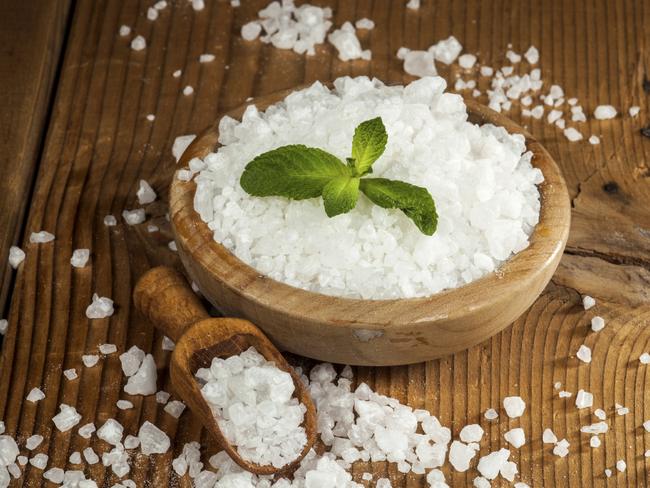 Sea salt in bowl and spoon on a wooden background.We Are What We Eat