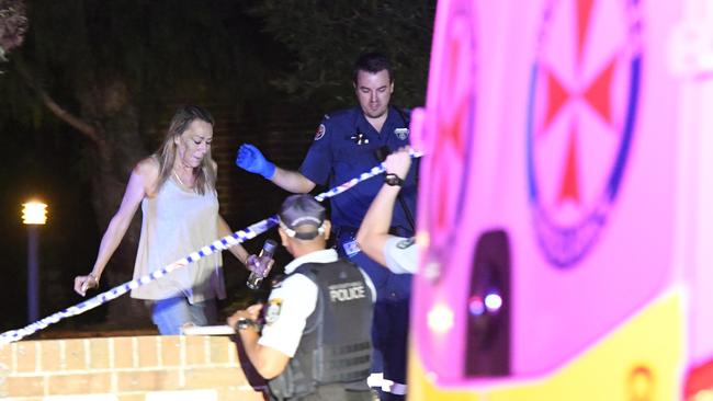 A woman leaves the townhouse with police. Picture: Gordon McComiskie