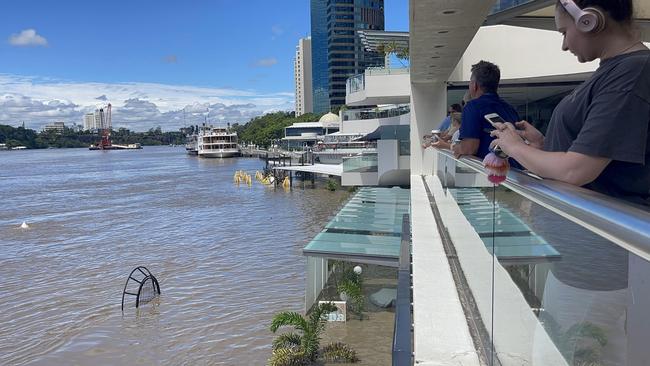 Local city residents watching flood waters go pass Eagle Street pier Picture Supplied