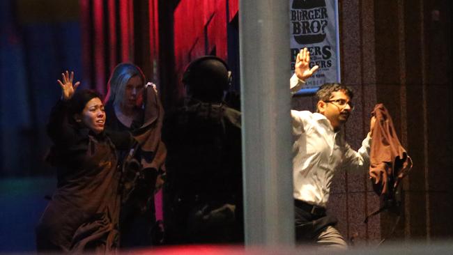 Hostages run to safety during the cafe siege. Picture: AP Photo/Rob Griffith