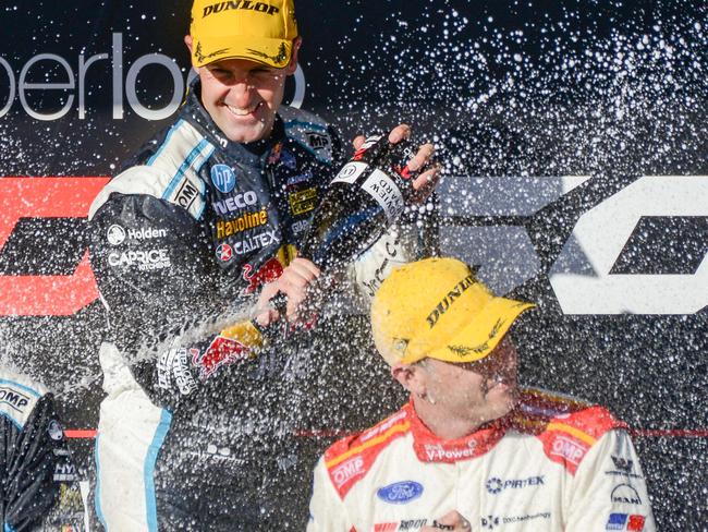 Rad Bull Racing driver Jamie Whincup, centre, sprays champagne on second place getter Scott McLaughlin, right, and third place Shane van Gisbergen after winning race one at the Adelaide 500 Supercar event, Saturday, February 22, 2020. (Photo: Brenton Edwards)