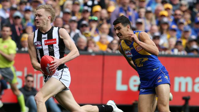 Jaidyn Stephenson runs away from Tom Cole to kick a goal in the first quarter. Picture: Michael Klein