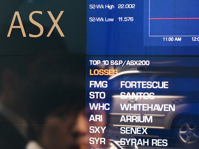 A man is seen in a reflection to stop to look at the electronic share board at the Australian Stock Exchange (ASX) in Sydney, Monday, Aug. 24, 2015. The ASX 200 has dipped below 5100 points for the first time in 18 months, as the big banks continue to bear the brunt of fear selling and with the big miners also getting hit on continued weakness in commodity prices. (AAP Image/Dan Himbrechts) NO ARCHIVING