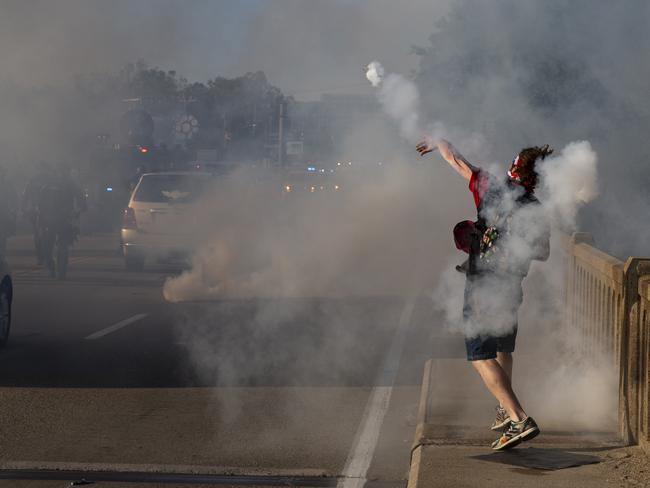 A protester throws a tear gas canister back toward Stafford County deputies. Picture: Mike Morones