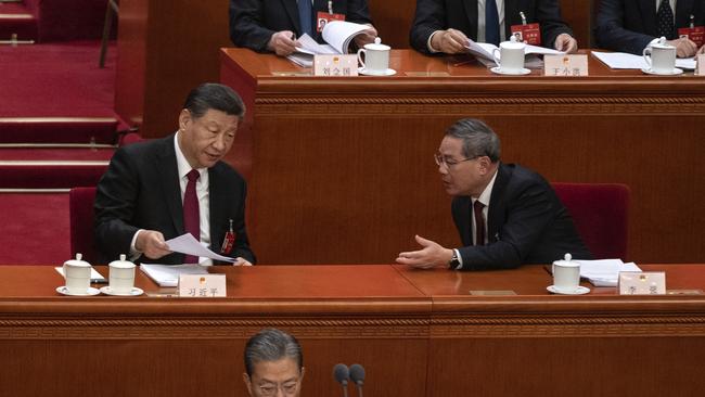 Chinese President Xi Jinping speaks to Premier Li Qiang after his speech at the opening of the NPC, or National People's Congress, at the Great Hall of the People on March 5 in Beijing.