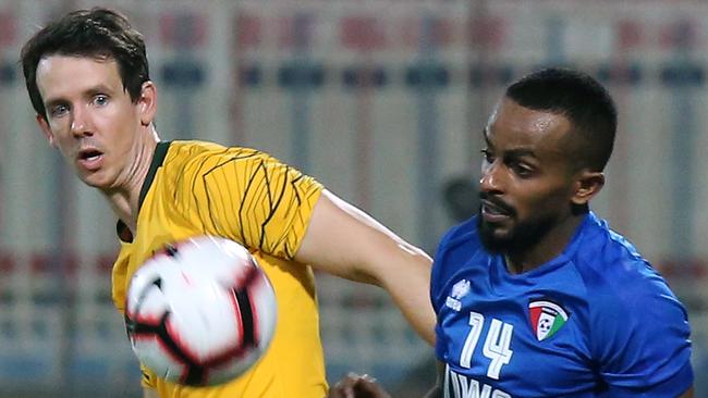 Australia's Robbie Kruse vies for the ball with Kuwait's Dhari Saed. Picture: AFP