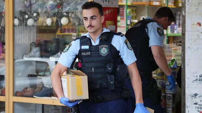 Police raid a store at Bankstown City Plaza in 2018 after police seized more than $200,000 cash and 4000 tins of baby formula. Picture: David Swift