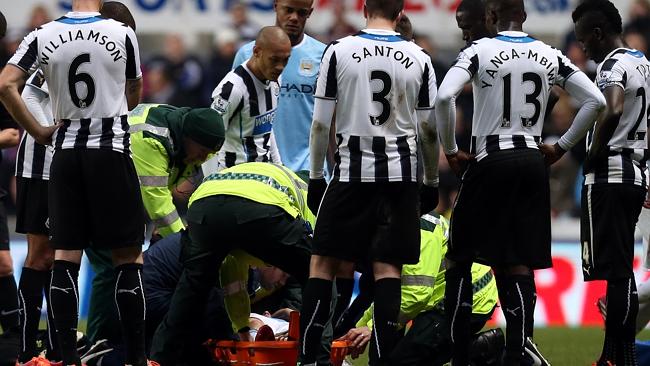 Manchester City's Samir Nasri, obscured from view, is carried from the pitch after a challenge by Newcastle United's Mapou Yanga-Mbiwa during their English Premier League soccer match at St James' Park, Newcastle, England, Sunday, Jan. 12, 2014. (AP Photo/Scott Heppell)