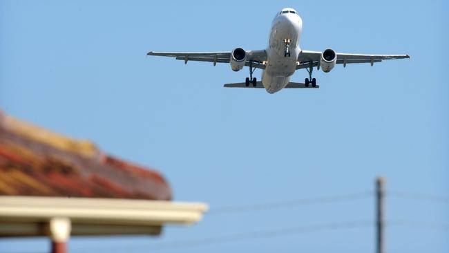 An jumbo jet aeroplane takes off from Adelaide Airport over the roof of a house on Knight Street, Richmond, SA.