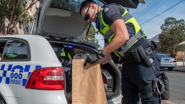 An officer bags evidence during the police sting. Picture: Jason Edwards