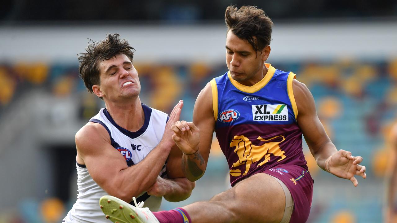 Callum Ah Chee (right) of the Lions gets his kick away during the Round 2 AFL match between the Brisbane Lions and the Fremantle Dockers at The Gabba in Brisbane, Saturday, June 13, 2020. (AAP Image/Darren England) NO ARCHIVING, EDITORIAL USE ONLY