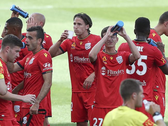 SOCCER - A-LEAGUE - Adelaide United v Newcastle Jets at Coopers Stadium. Drinks break due to hot weather - Louis D'Arrigo splashes water on his fast while Michael Marrone takes a drink in the background Picture SARAH REED