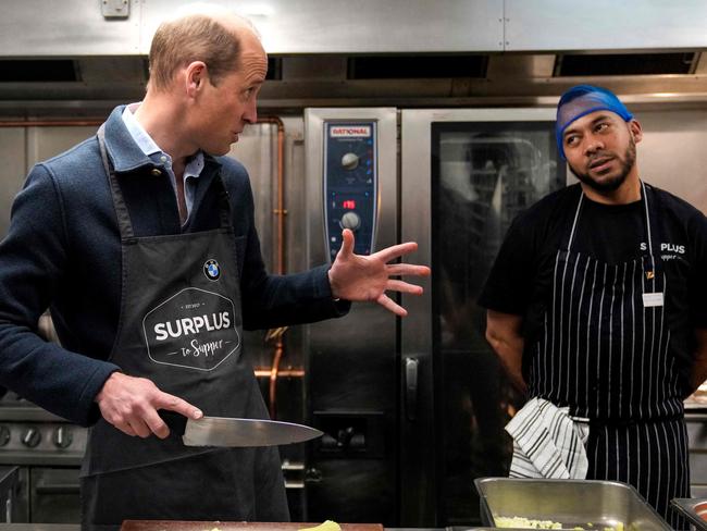 Prince William receives a few directions in the kitchen. Picture: AFP