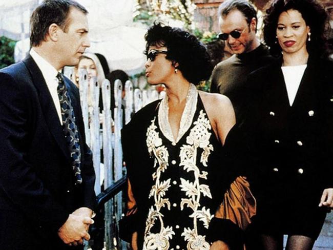 Still from movie The Bodyguard: Kevin Costner, Whitney Houston and her stage sister.