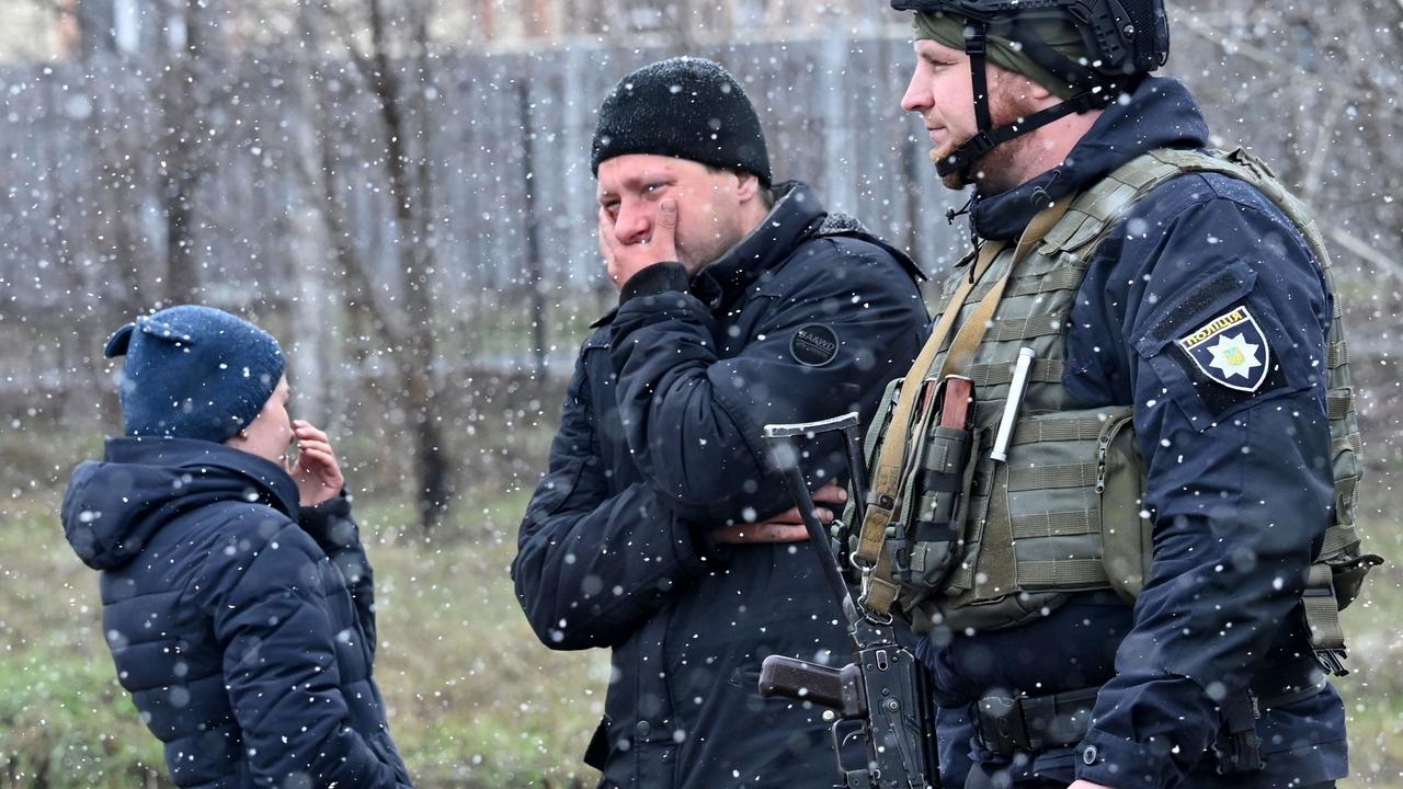 People react as they gather close to a mass grave in the town of Bucha. Picture: Sergei Supinsky/AFP