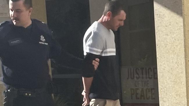 A handcuffed Walton Bevan is led to jail after being busted trying to defraud the ATO