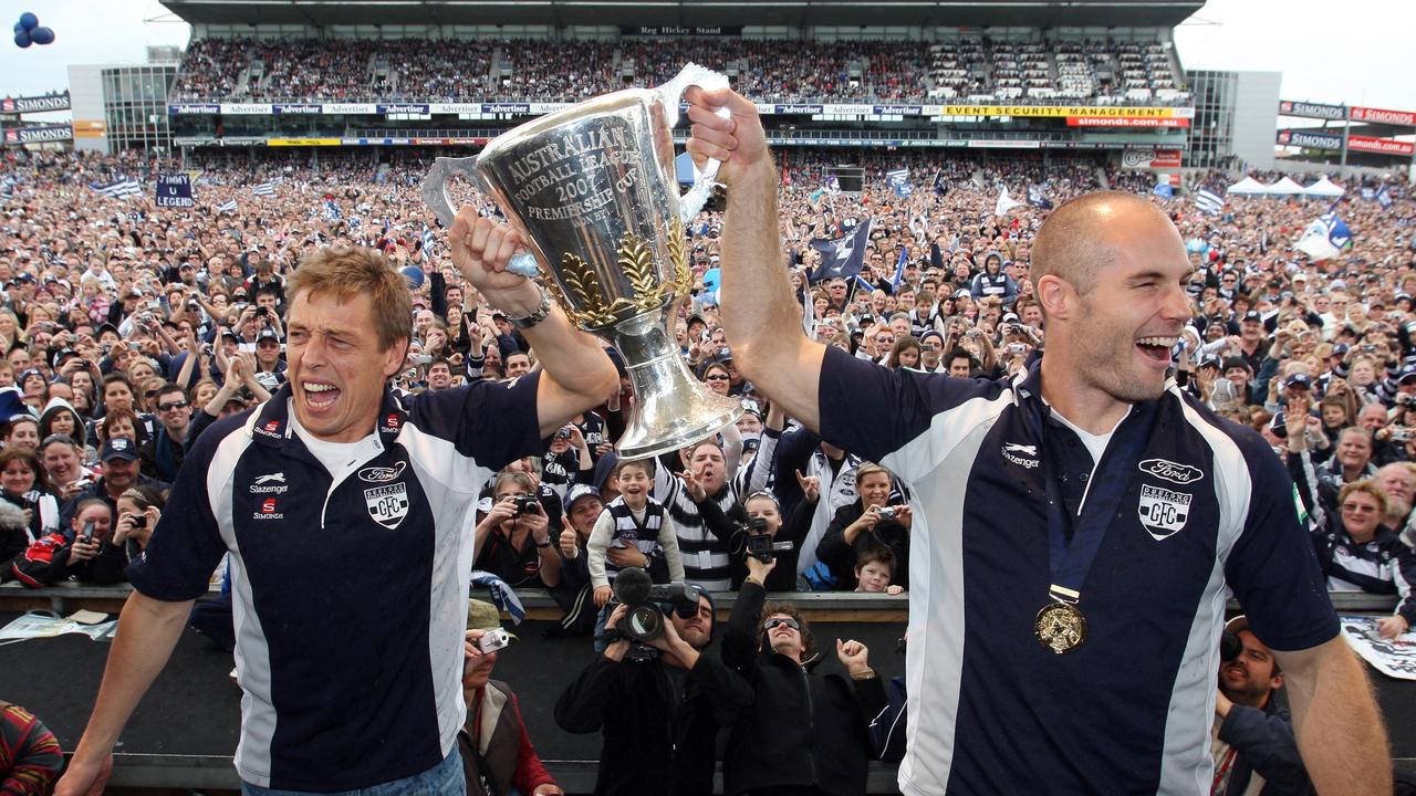 Cats coach Mark Thompson with club captain Tom Harley holding the 2007 premiership cup trophy in front of the crowd at Skilled Stadium.