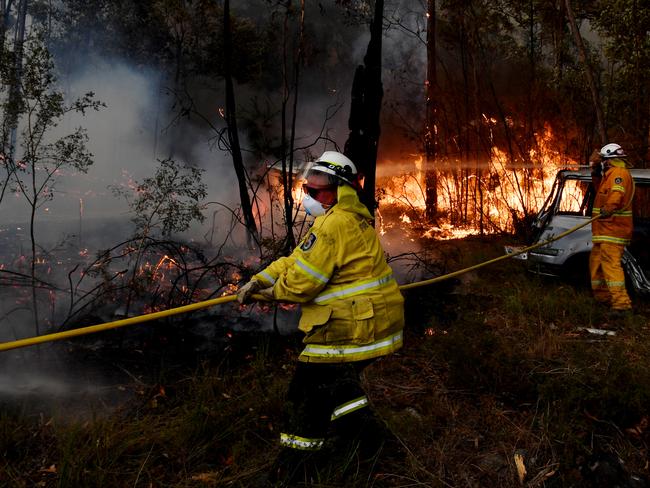 SYDNEY, AUSTRALIA - DECEMBER 31: Rural Fire Service (RFS) firefighters conduct property protection near the town of Sussex Inlet on December 31, 2019 in Sydney, Australia. There are a number of dangerous bushfires burning at emergency level across NSW as weather conditions deteriorate with temperatures expected to rise ahead of gusty southerly change. Princes Highway on the NSW South Coast has been closed with motorists told to avoid all non essential travel. Volunteer firefighter Sam McPaul was killed when his truck rolled over in a freak wind event near Jingellic near the NSW-Victorian border on Monday evening. (Photo by Sam Mooy/Getty Images)