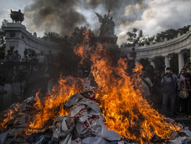 MEXICO CITY, MEXICO - MAY 26:  Demonstrators burn election posters after a rally to ask Mexican authorities to continue the search for the 43 kidnapped students by local police officers since September 26, 2014 in southern state of Guerrero on May 26, 2015 in Mexico City, Mexico. Relatives of the missing students have called the Global Day of Action for Ayotzinapa's students to demand their safe return. (Photo by Miguel Tovar/LatinContent/Getty Images)