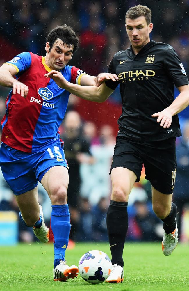 Jedinak hassles Edin Dzeko, of Manchester City.