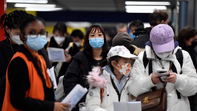 Passengers of a flight from China wait in a line for checking their COVID-19 vaccination documents as a preventive measure against the Covid-19 coronavirus, after arriving at the Paris-Charles-de-Gaulle airport in Roissy, outside Paris, on January 1, 2023. - France and Britain on December 30 joined a growing list of nations imposing Covid tests on travelers from China, after Beijing dropped foreign travel curbs despite surging cases -- and amid questions about its data reporting. (Photo by JULIEN DE ROSA / AFP)