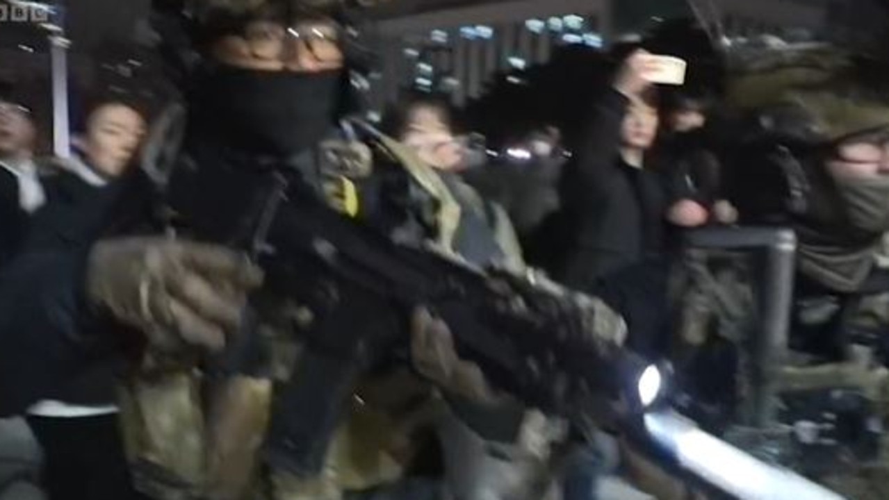 Woman grabs soldier’s gun amid South Korea chaos. Picture: BBC