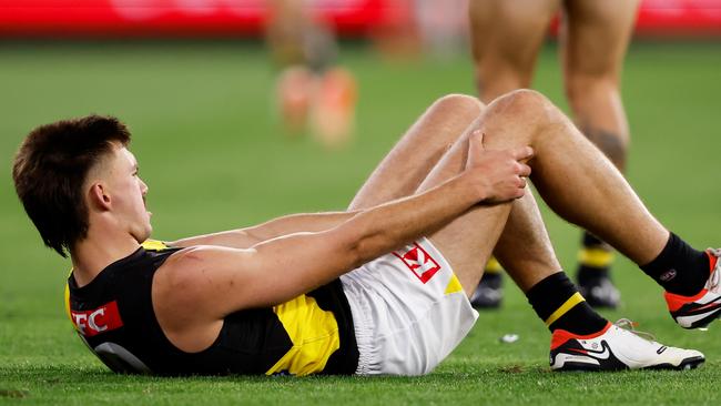 Josh Gibcus grabs at his right knee after rupturing his ACL in a marking contest during the second quarter against Carlton on Thursday night at the MCG. Picture: Dylan Burns / Getty Images