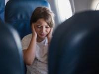 Young girl having a severe earache during a airplane flight and crying