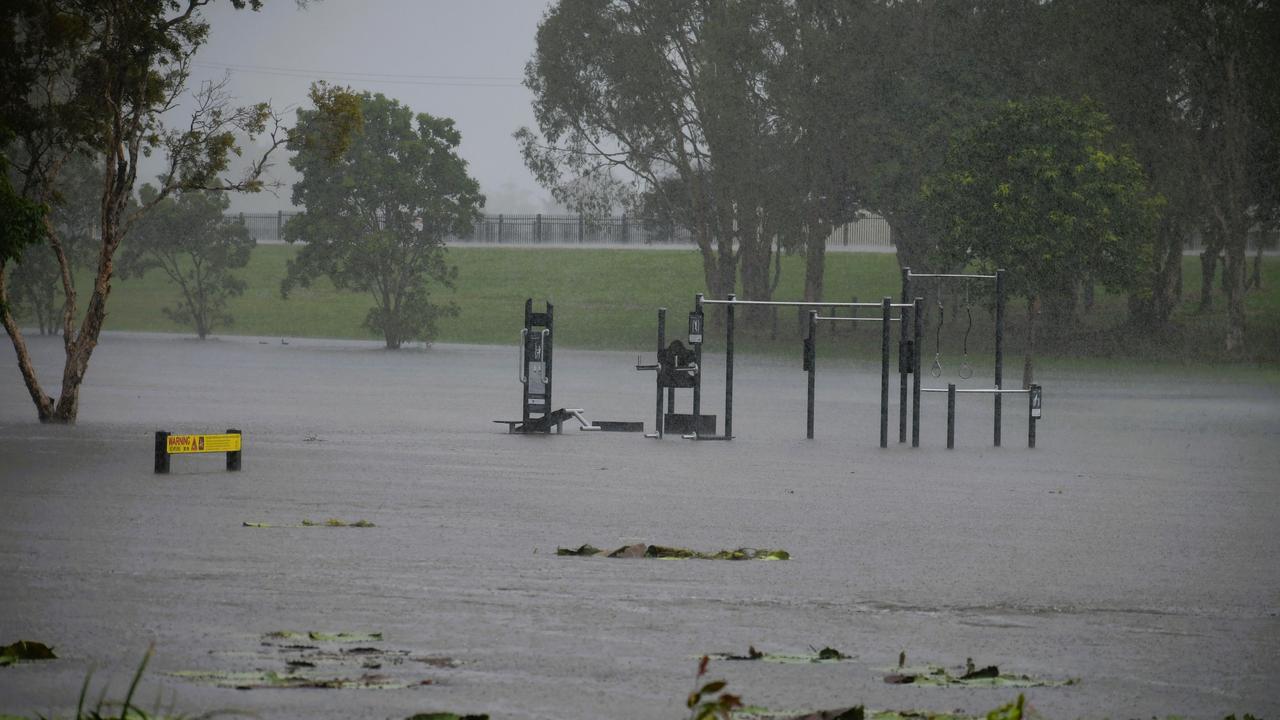 A flooded park and crocodile-warning sign opposite Ingham State High School. The floods in Hinchinbrook Shire, North Queensland. Picture: Cameron Bates