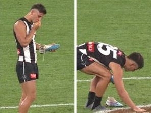 Nick Daicos places a rose petal on the MCG turf in honour of his late grandfather. Photo: Ch 7