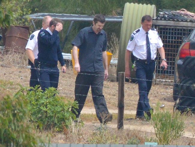 Accused Gene Bristow, in blue short sleeved shirt, with sheriffs officers on his property in Meningie. The court, along with jury members visit the property, Wednesday, February 6, 2019.  It is the scene where a European backpacker was allegedly kept chained against her will in February 2017. (Picture: Brenton Edwards)  - NO JURORS IN THE PICS