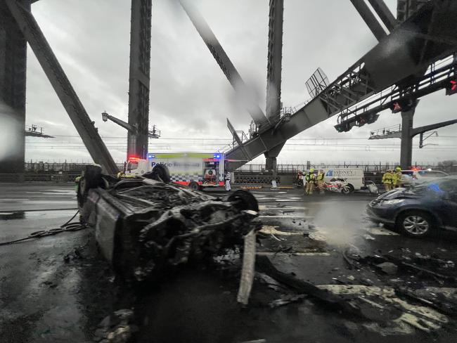 Three vehicles were involved in a crash on the main deck of the Sydney Harbour Bridge, where one car flipped onto its roof and caught alight. Picture: Ryan Osland