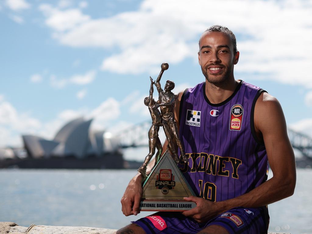 Xavier Cooks of the Kings poses with the NBL Championship trophy.