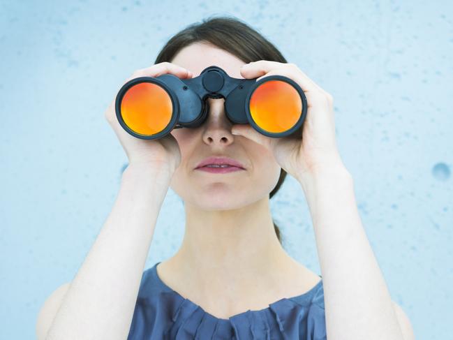 Business vision: woman holding binoculars. istock