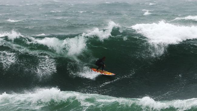 A surfer takes on a massive wave at Bondi. Picture; John Grainger