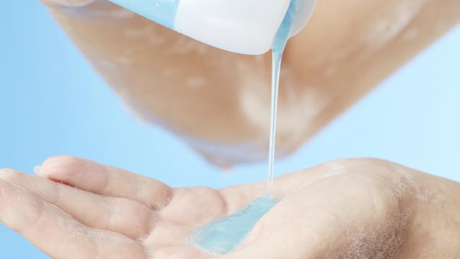 Bottle of shower gel in woman's hands